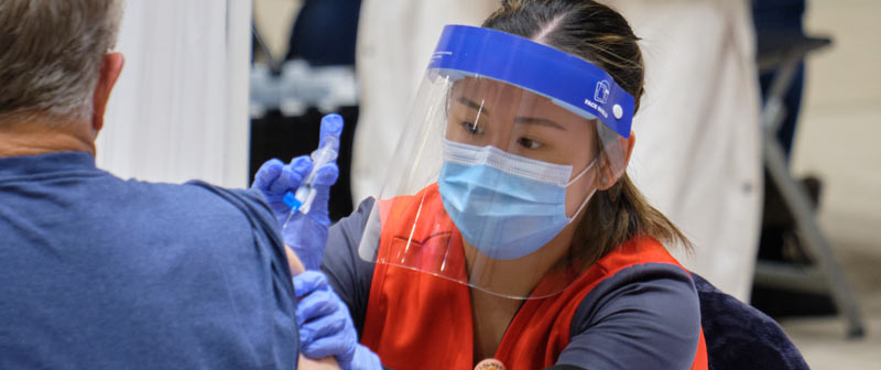 A PLU nursing student administers a COVID-19 vaccination.