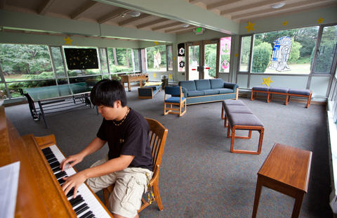 PLU student Kai Davis ’14playing the piano in Foss Hall.