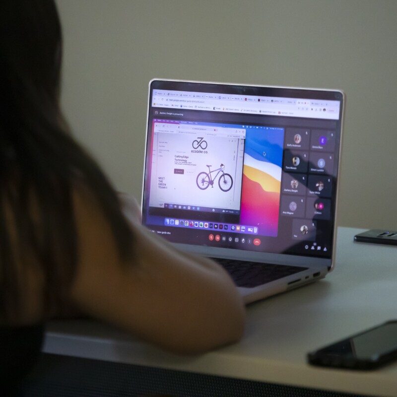 A student working on a graphic design project on a laptop