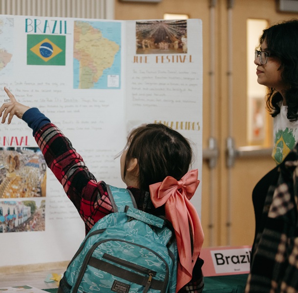 A child pointing at the poster with countries on it