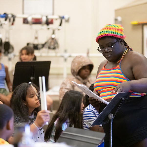 A student leading a music camp