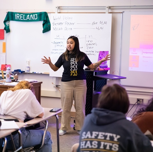 A student in front of a white board leading a class