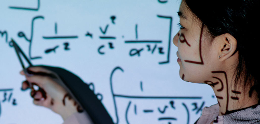 A student points to a board with math formulas on it