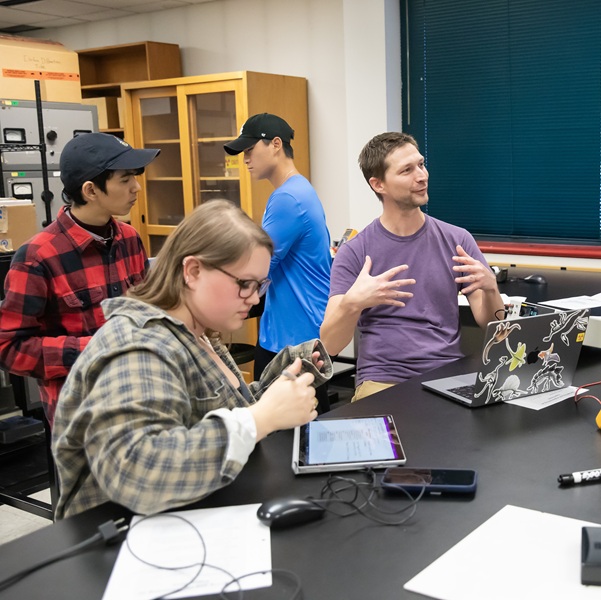 Students working with big coils of wire and magnetic fields in a classroom