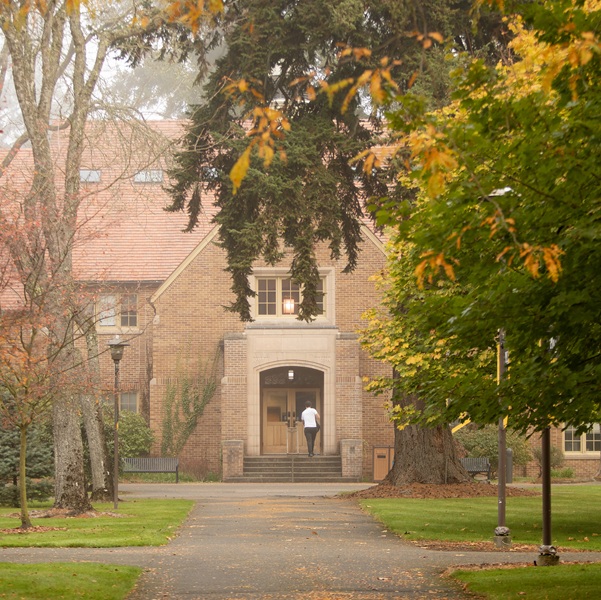 Students walk past Xavier Hall on a foggy fall morning.