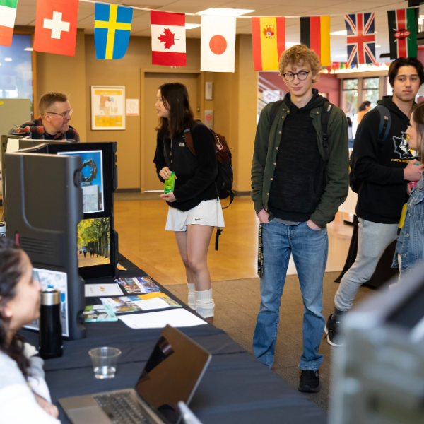 Students walking in UC while flags are hung up right on top of them