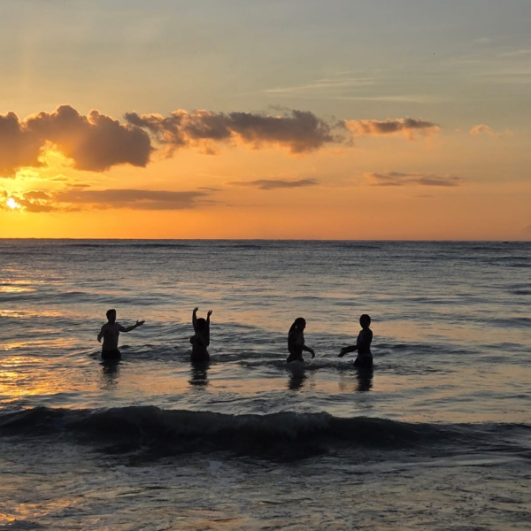 PLU Students going for swim at beach while the sun sets