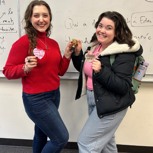 students smiling one wearing red one wearing pink