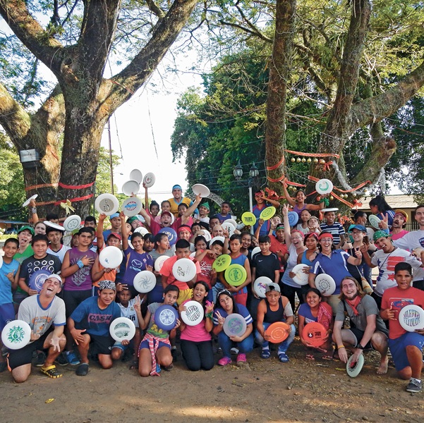Students with frisbees posing in a group photo