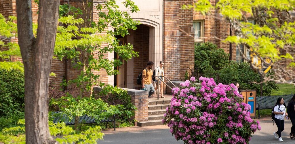 Two students walking out on the steps of Xavier hall in springtime.