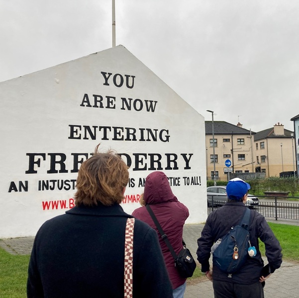 Study Away students students on a tour in Ireland looking at a sign