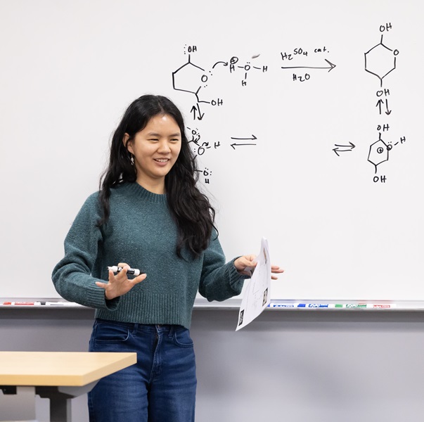 Student speaking in front a white board