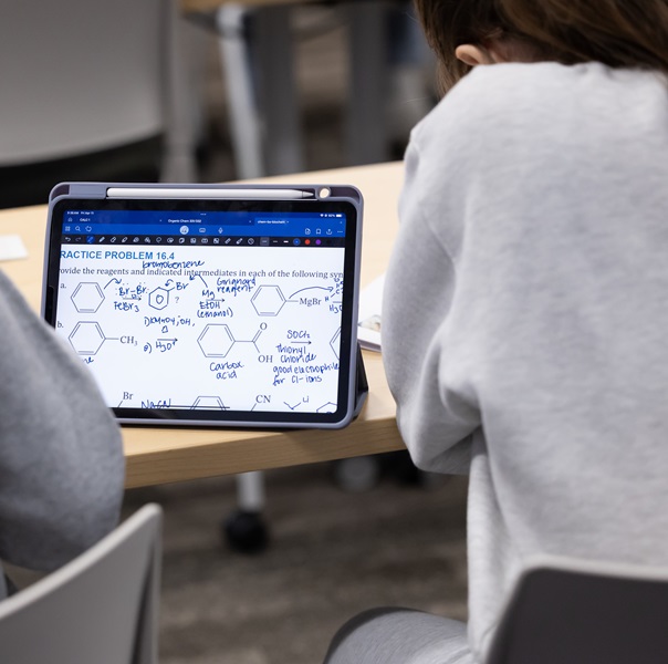 Student at a desk working on a laptop