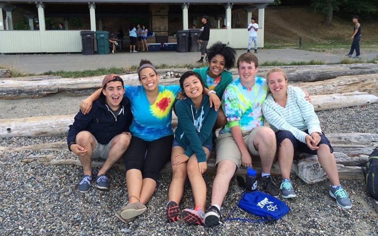 PLU students pose on the beach at Point Defiance Park.