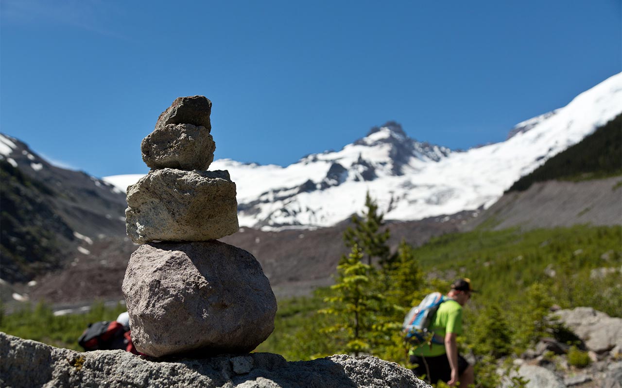 Rocks balanced and piled, looking toward Mount Rainier during a hike by PLU students.