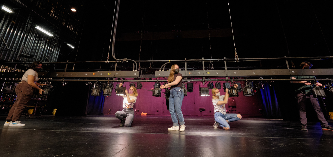 Five students focusing lights in a lighting design class in Eastvold Auditorium