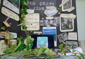 PLU GREAN Club's informational poster and table with fake greenery at the Spring Engagement Fair.