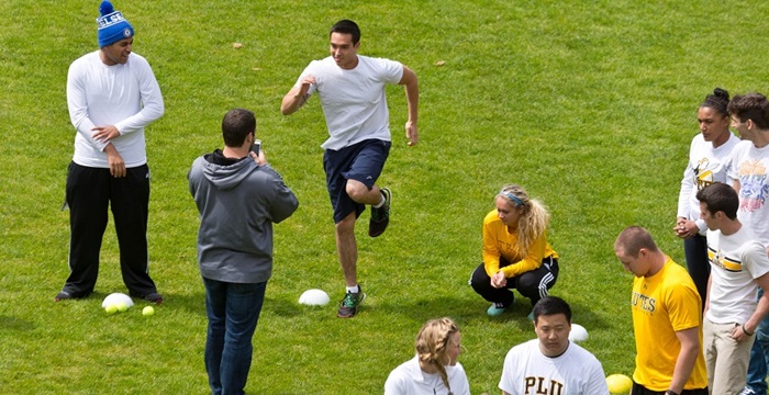 Students do exercises outside during a kinesiology class on campus