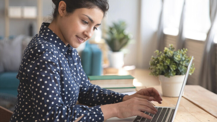 A female student writing an essay on her computer.