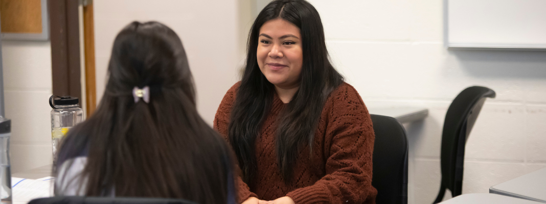 Two students talking during group discussion in class.