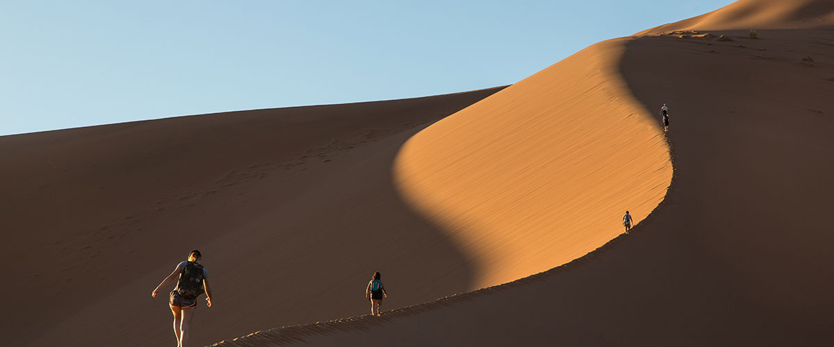 Students walking on sand dunes in Namibia