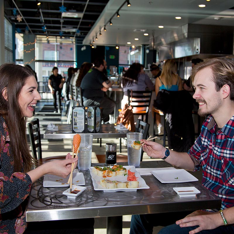 Two people eating sushi at Trappers