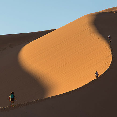 Students walking on sand dunes in Namibia