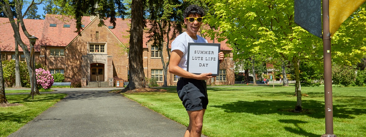 A student holding a sign that reads 'Summer Lute Life Day'