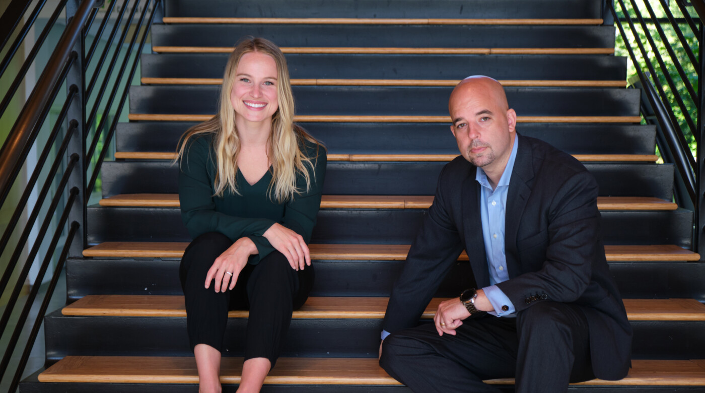 PLU Alumna Andrea Adams ‘15 and Bradd Busick ’99, MBA ’09 pose on steps.