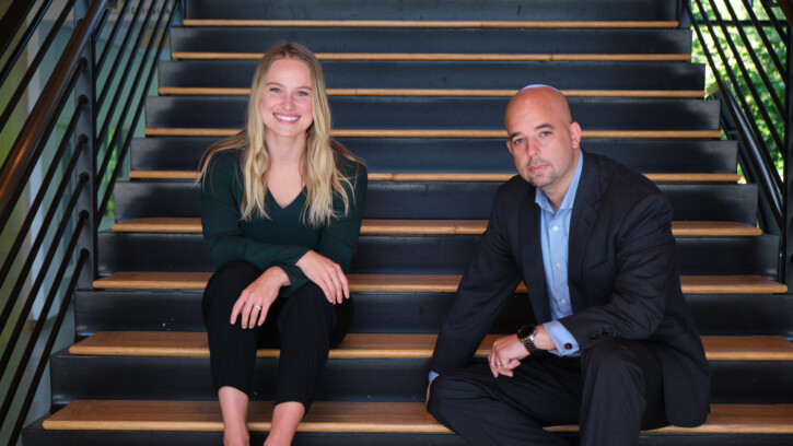 PLU Alumna Andrea Adams ‘15 and Bradd Busick ’99, MBA ’09 pose on steps.