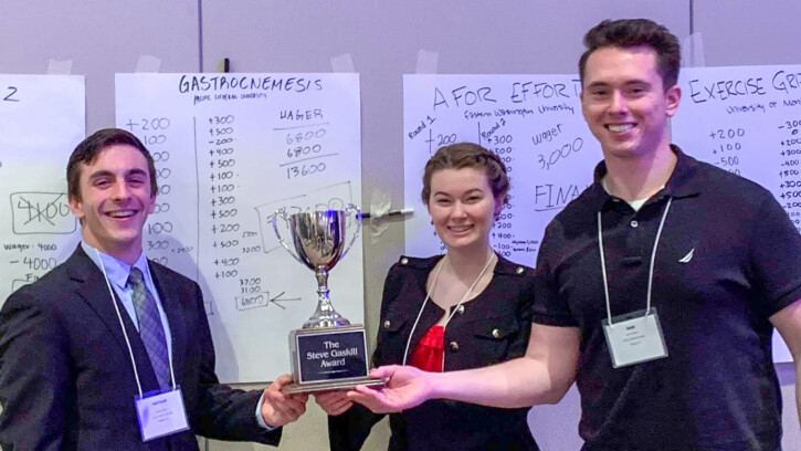 2020 PLU NW Regional ACSM Knowledge Bowl champions Nate Adams, Brianna O’Malley and Sam Crompton stand together holding their trophy.
