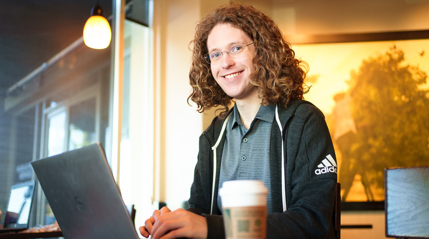 Conover typing on this laptop. He's seated in a coffee shop, a Starbucks up is just a few inches from his computer