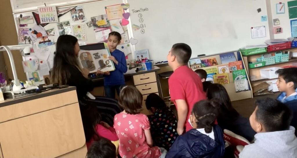 Sophia Barro reads a book to a class of students.