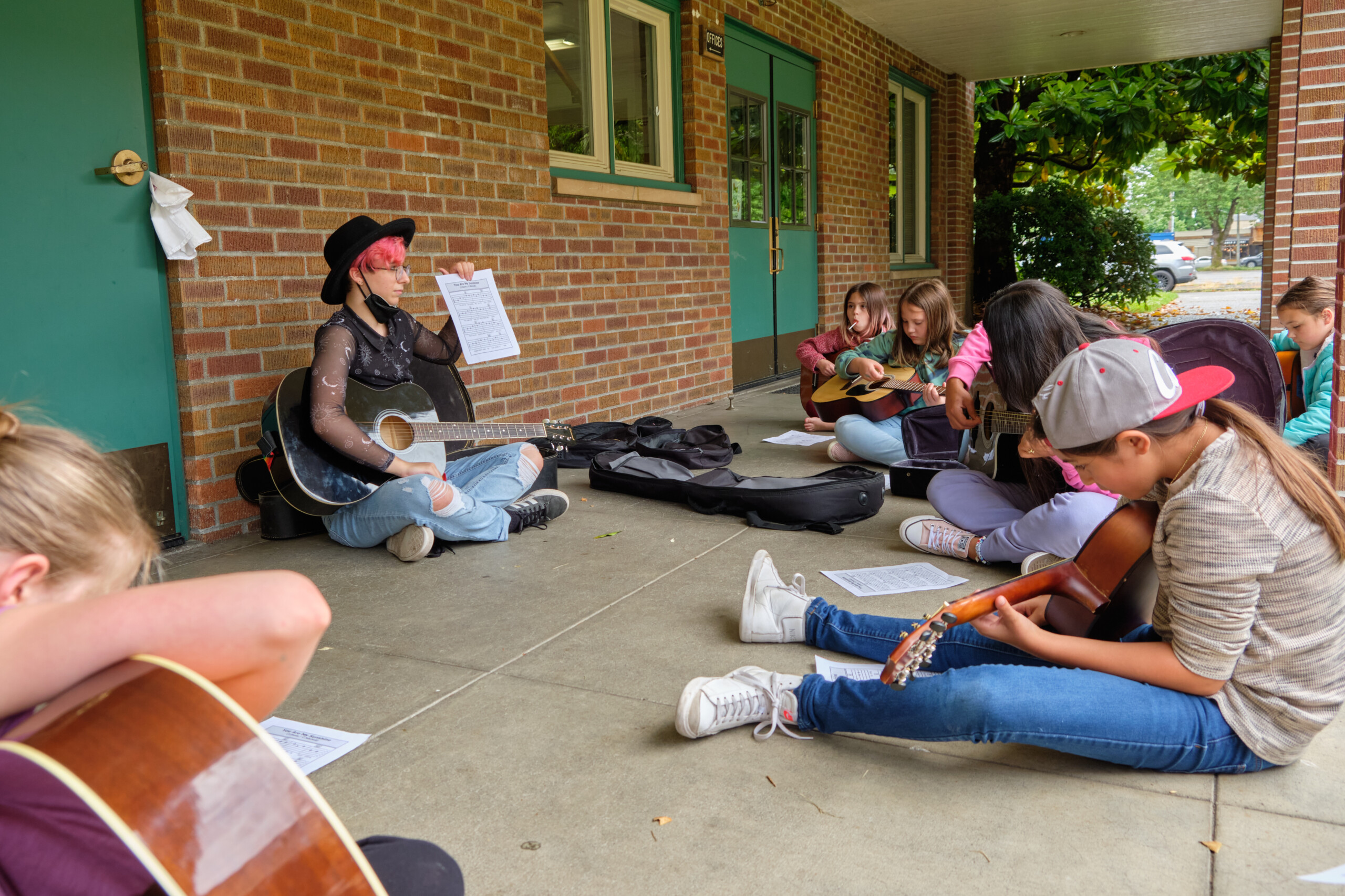 Ashton Allen ’25, music education major with a high school band focus teaches guitar to campers.