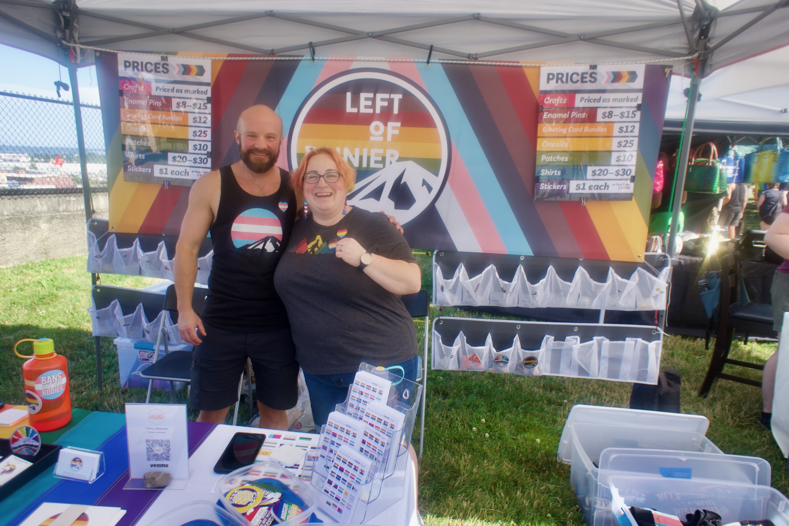 Two people smile into the camera wearing pride gear at Tacoma Pride 2023.