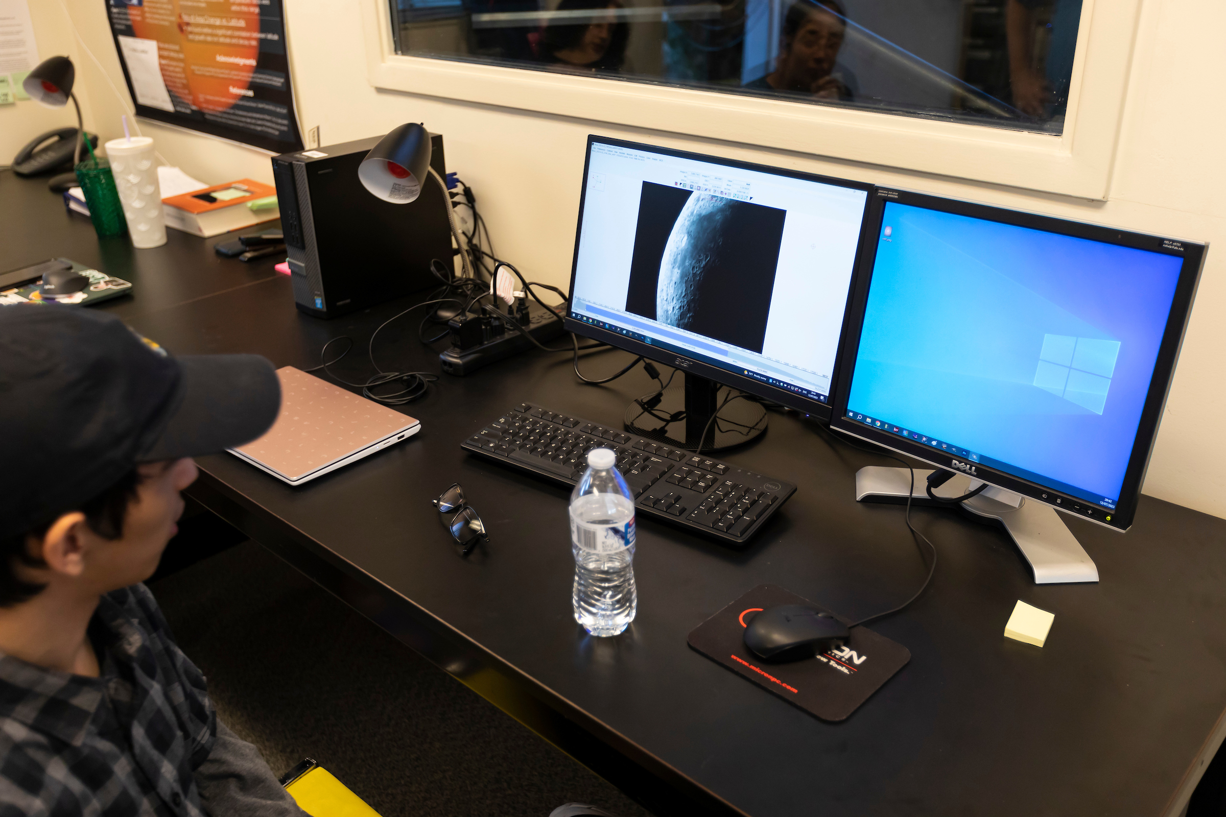 A student looks at a computer screen that has a moon on it.