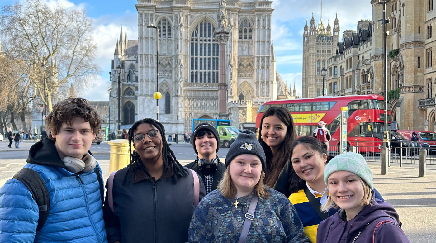 Students smile into the camera and stand in downtown London.