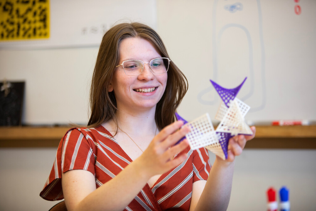 Students holds up a math model in front of the camera.