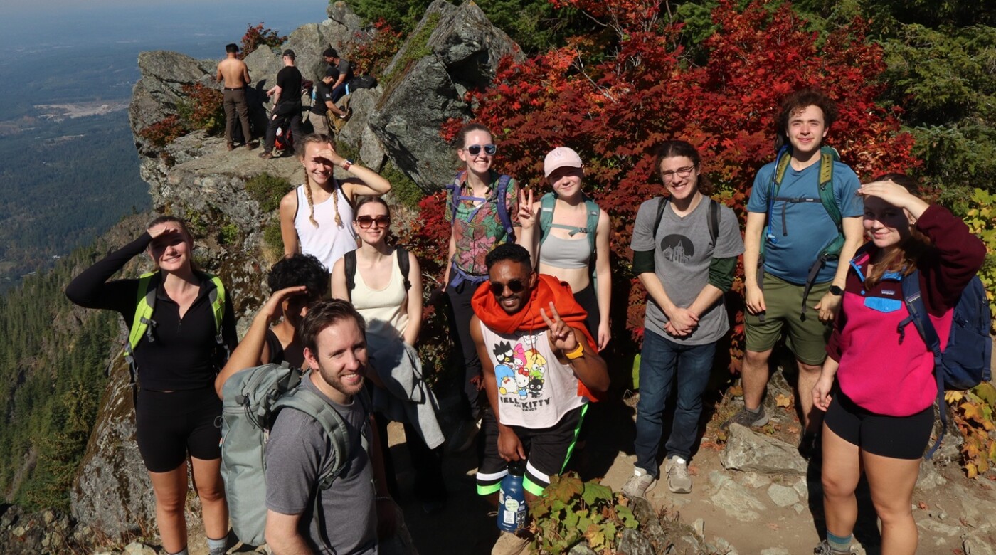 A group of PLU students smile at the camera on the summit of Mount Si on an Outdoor Rec hike.