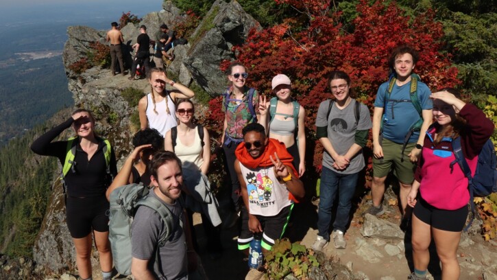 A group of PLU students smile at the camera on the summit of Mount Si on an Outdoor Rec hike.