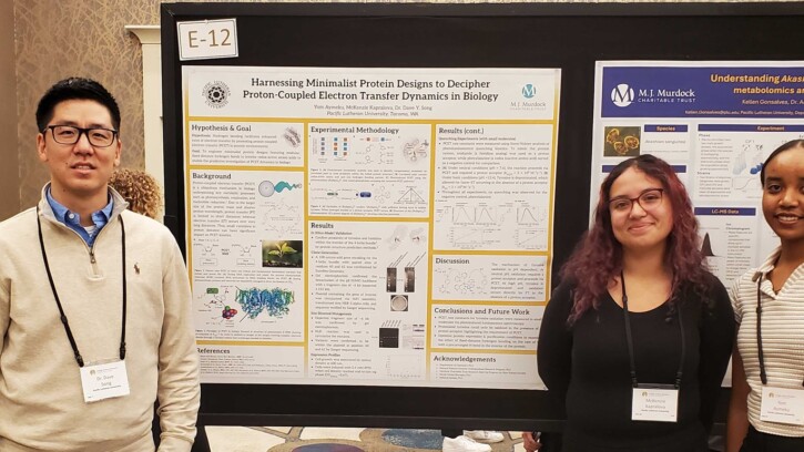 Students standing in front of the research banner