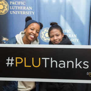 Two students holding #PLUThanks sign