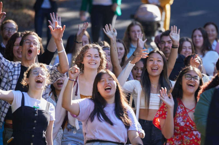 A group of PLU students cheering together on campus