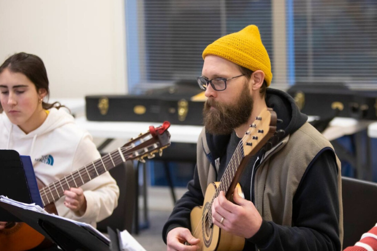 PLU students playing guitar in class.
