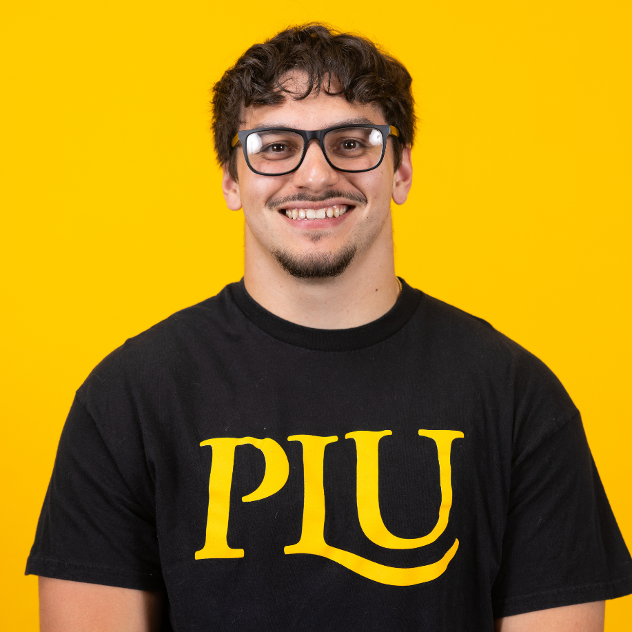 student wearing a plu shirt smiles into the camera
