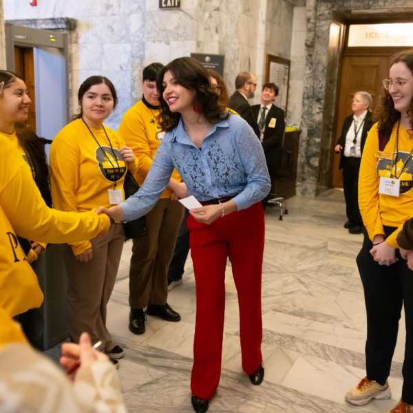 Rep Mena shakes hands with students