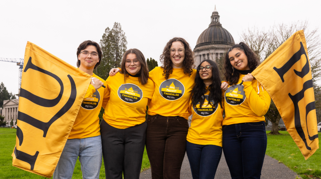 students in front of the capitol holding PLU banners