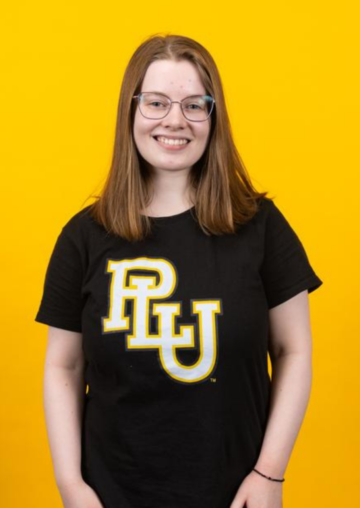 Smiling girl wearing glasses and PLU t-shirt on yellow background