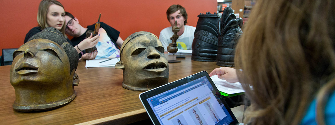 Student Research Team looking at wood carvings