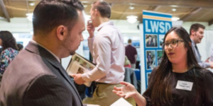 Image of a recruiter speaking with a student at a career fair at PLU